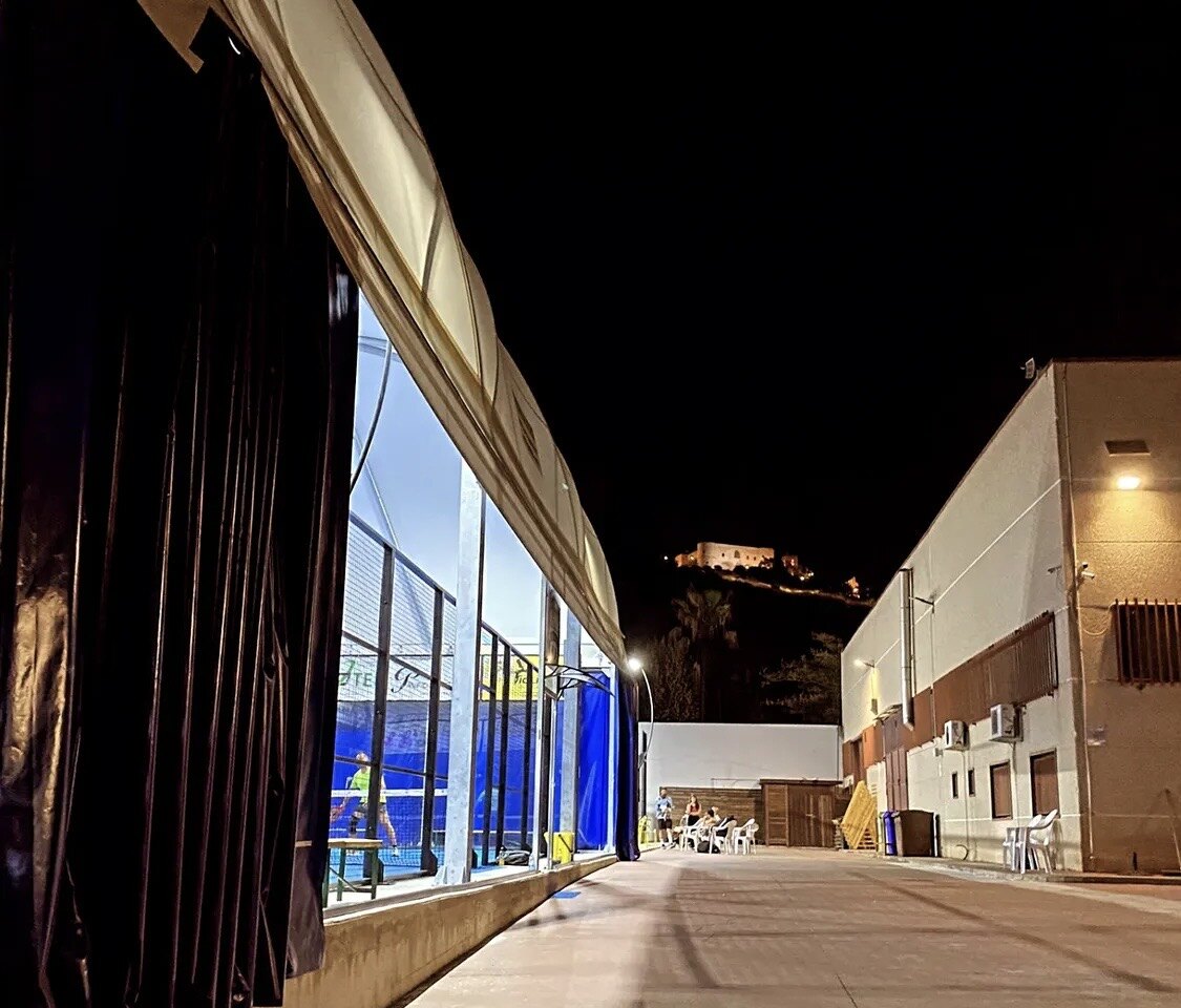 Ingresso del Piroda Padel Club di sera, con il castello di Bernalda sullo sfondo